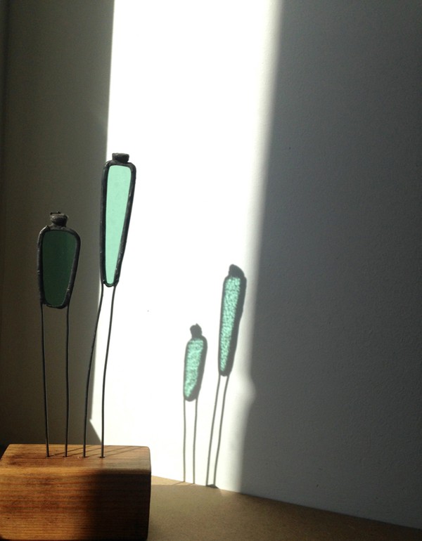 Statuettes et reflets sur mur blanc